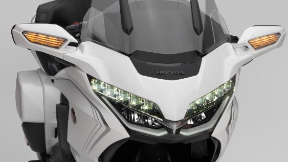 Close-up of white Honda motorcycles with lights lit up