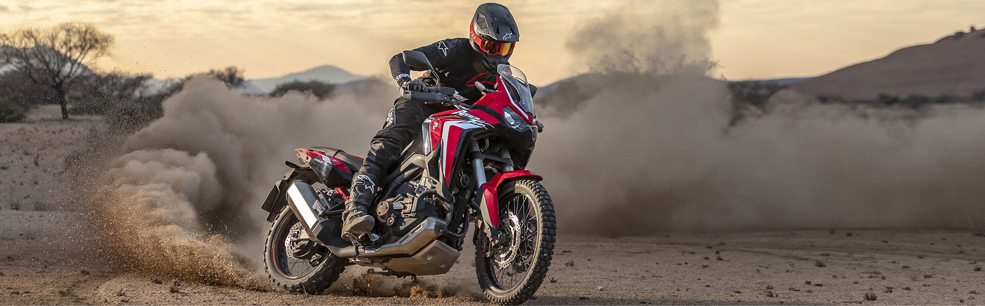 Person drifting on a Honda Africa Twin in a desert