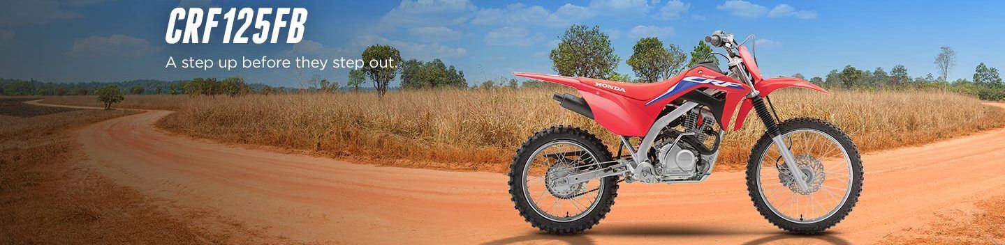 2022 Honda CRF125FB side view with grassy background and lettering