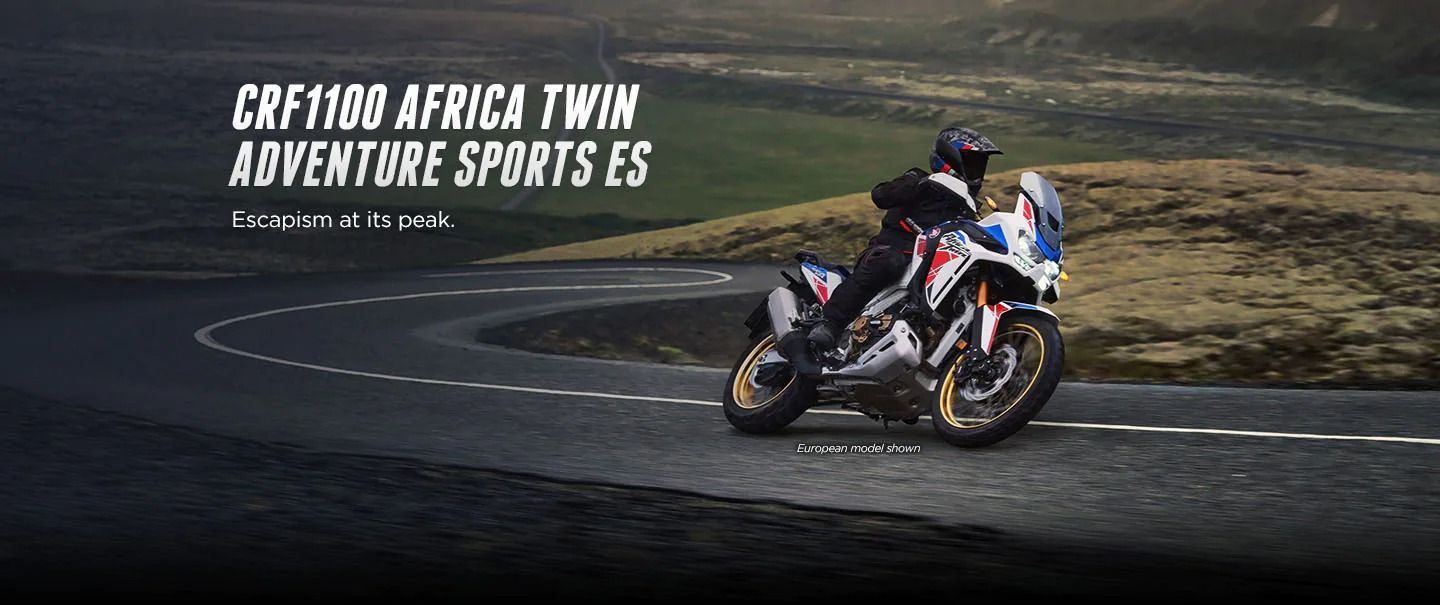 Person driving Honda Africa Twin Adventure Sports around turn with lettering up above