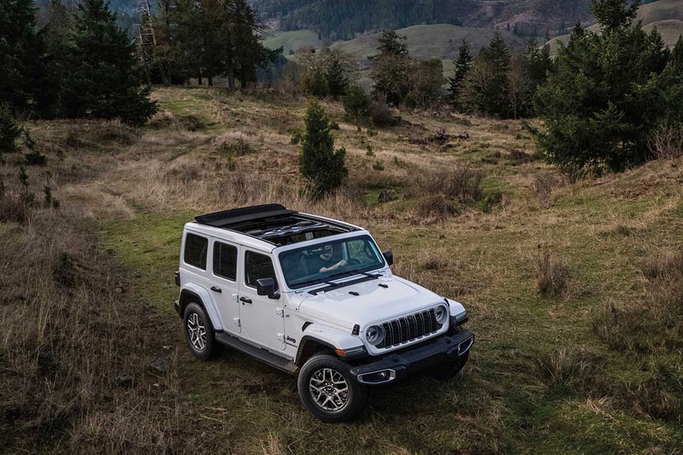 2026 Jeep Wrangler driving through grassy terrain