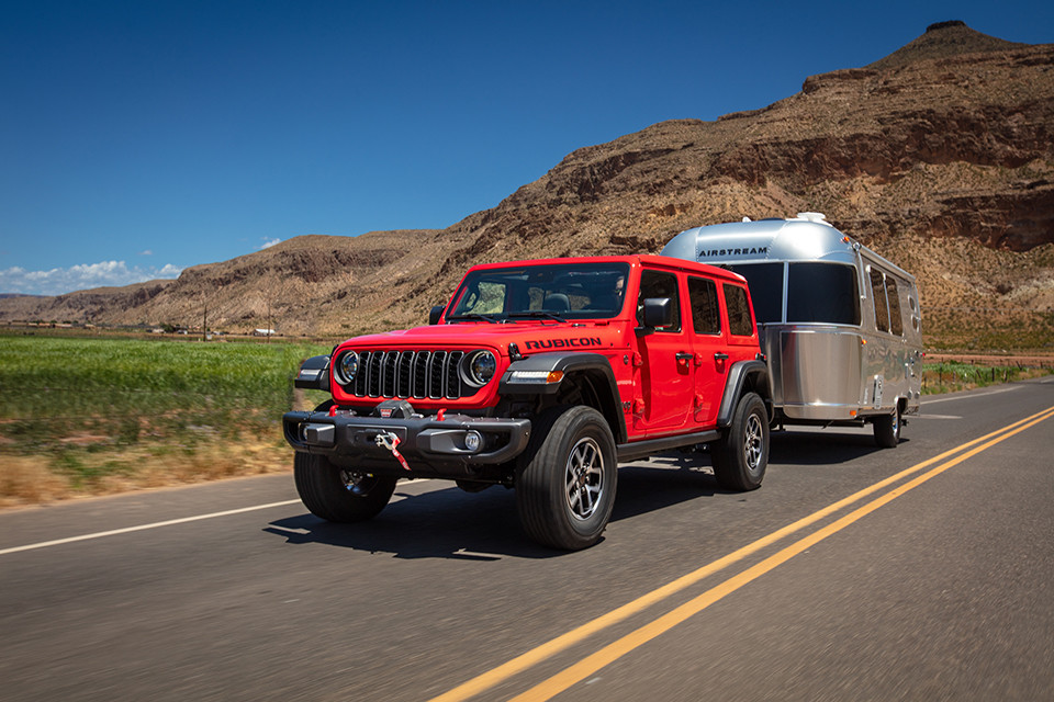 2026 Jeep Wrangler pulling trailer down the road