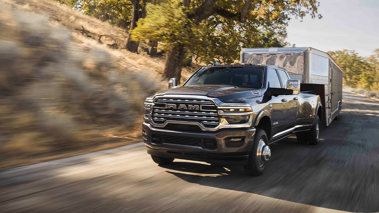 Ram 3500 pulling large trailer up the road