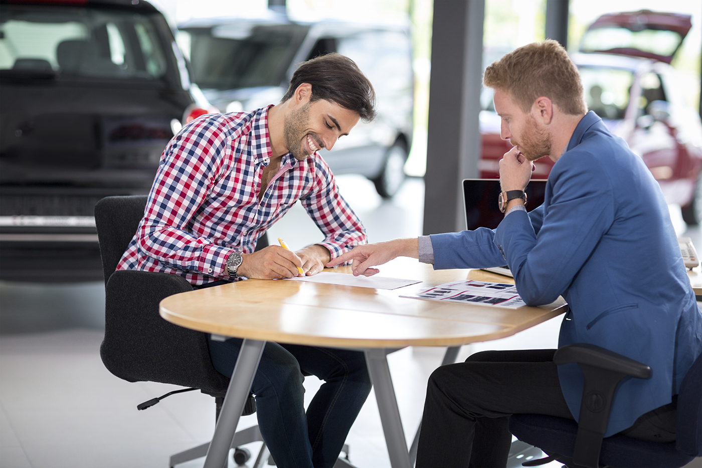 Happy man buy new car in car showroom