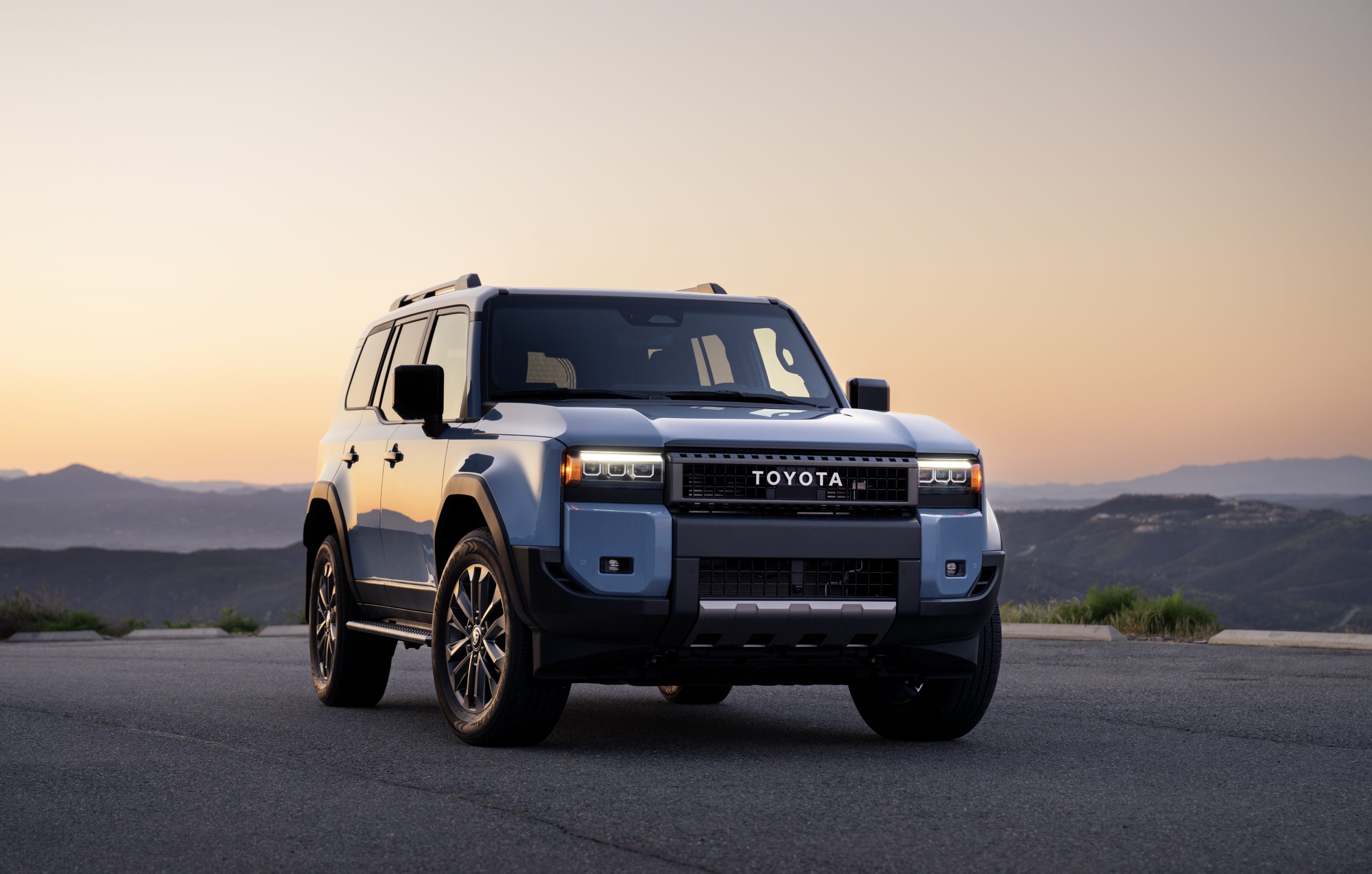 2026 Toyota Land Cruiser in Heritage Blue parked on a mountain road at sunset