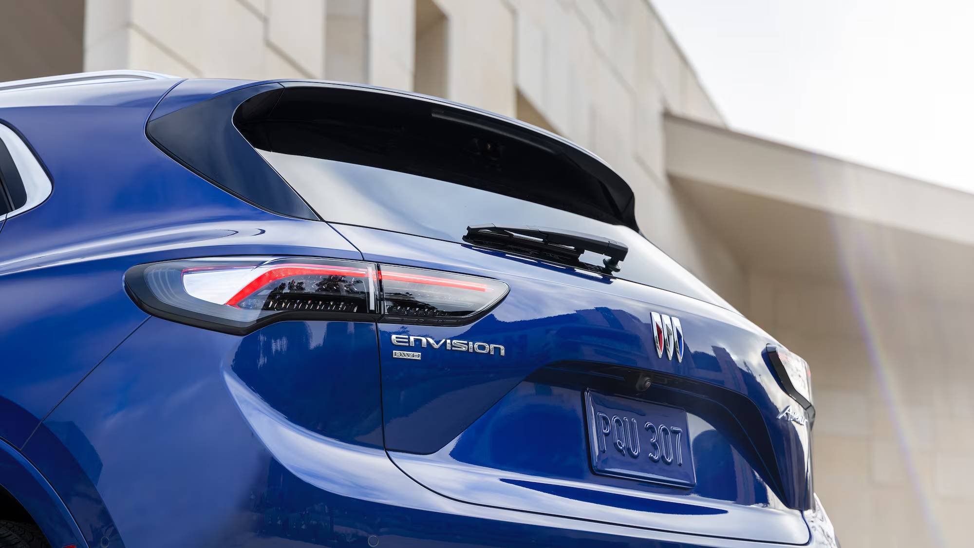A closeup of a blue 2025 Buick Envision's tailgate and rear spoiler