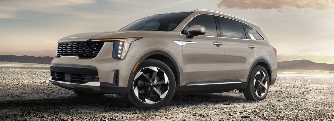 A pale brown 2026 Kia Sorento PHEV parks in front of a sunset