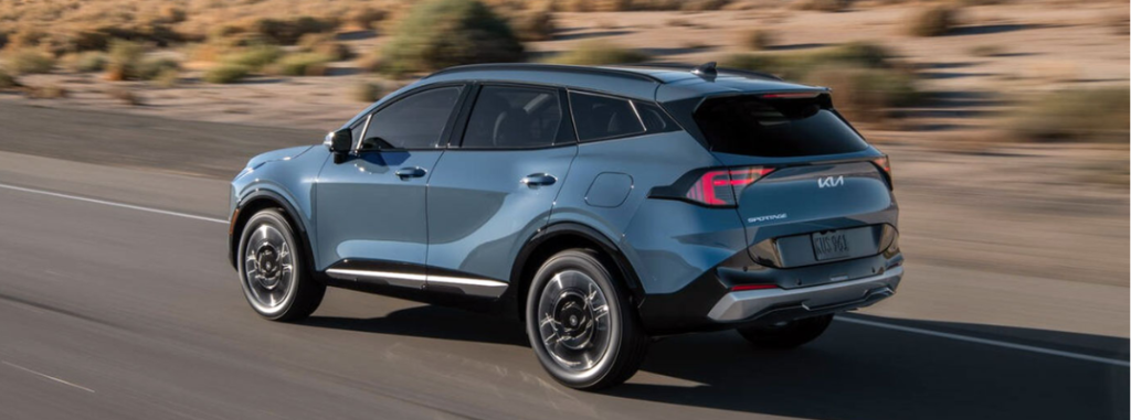 2026 Sportage HEV driving down a rural road