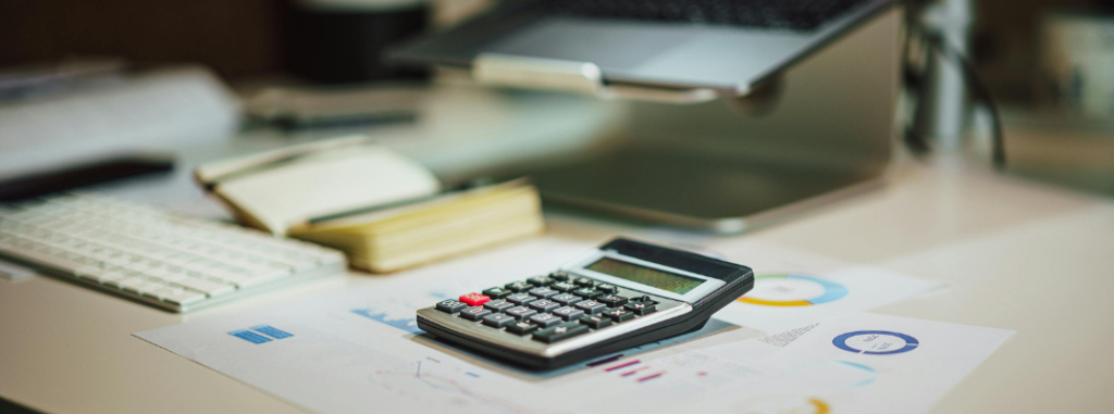 A calculator on a stock of papers on a desk