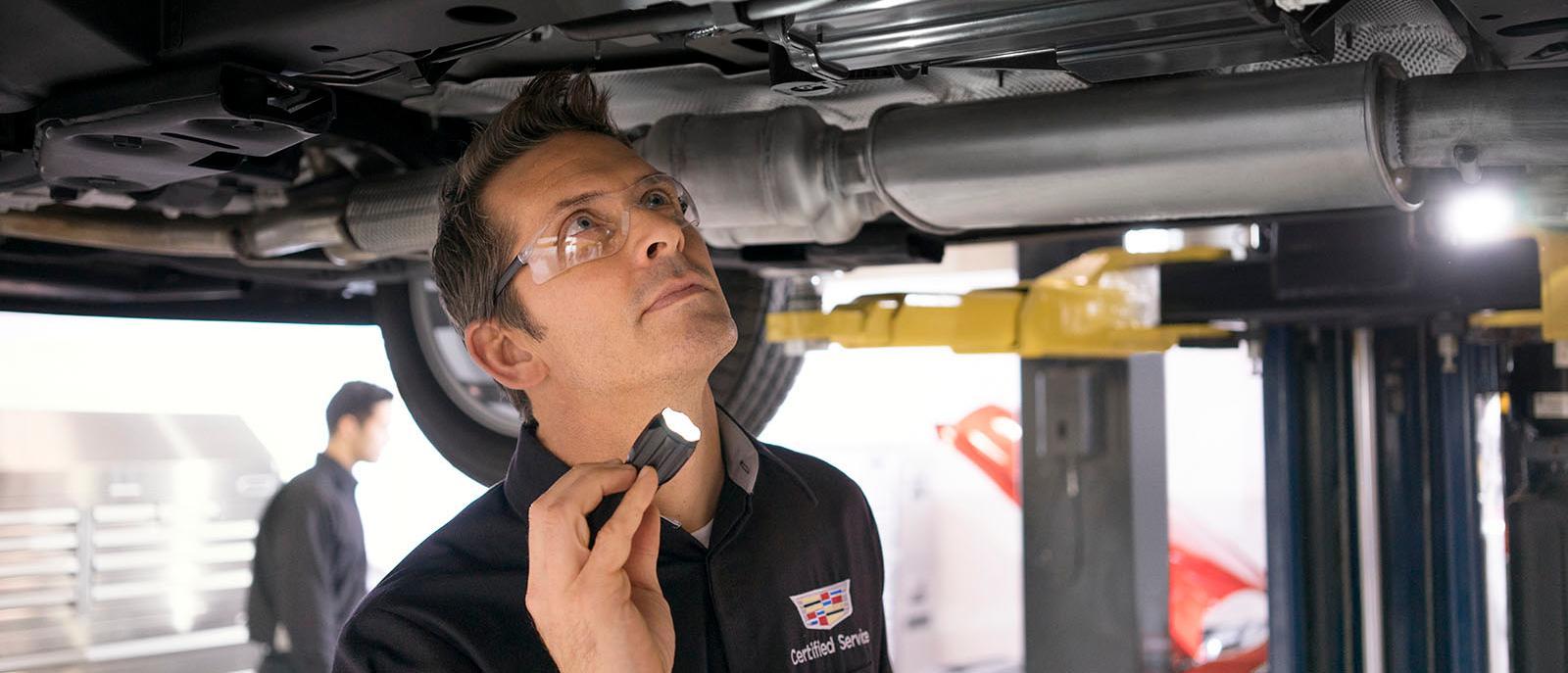 An Image of a Technician inspecting a vehicle's undercarriage