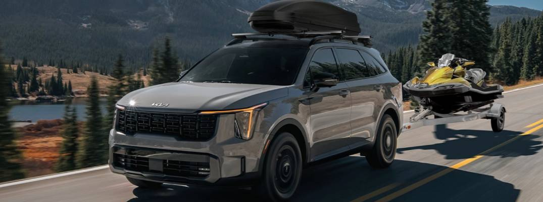2025 Kia Sorento pulling a boat. Has roof box on top. 