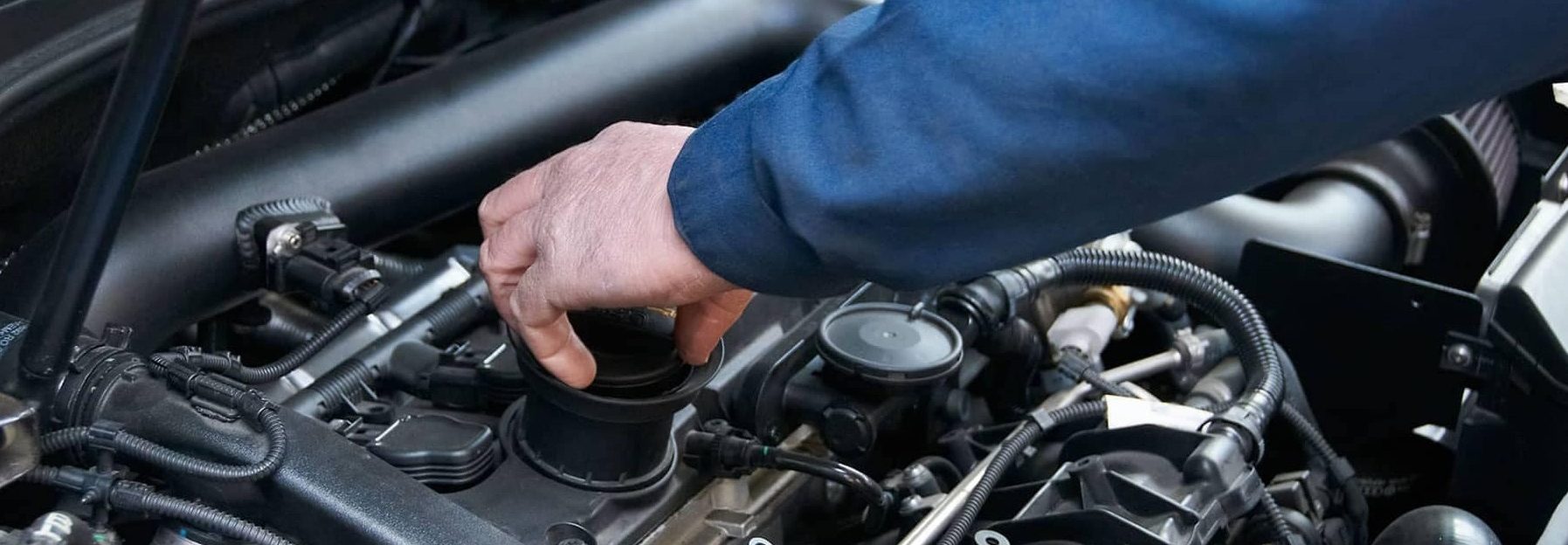 Technician working on vehicle engine