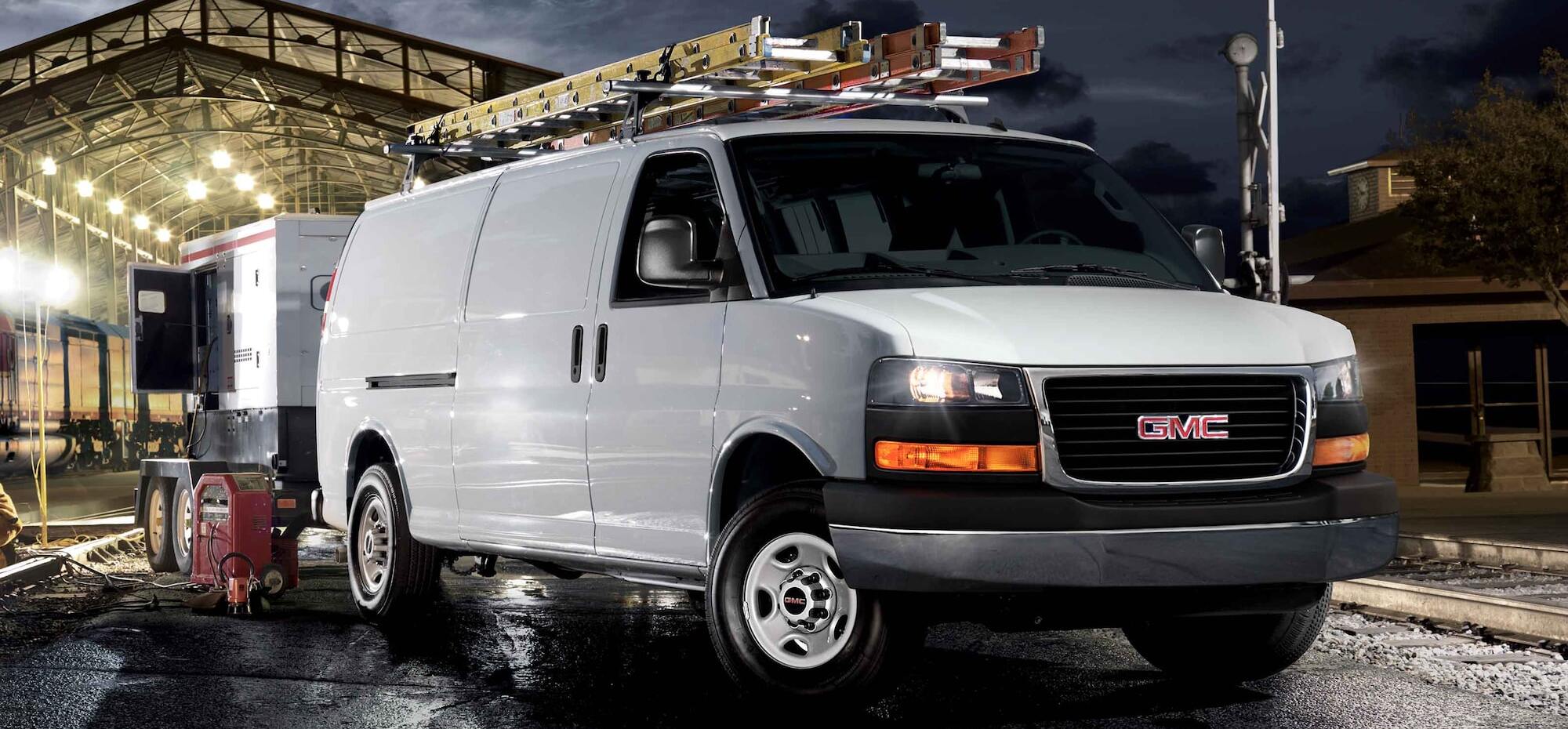 A white 2025 GMC Savana Passenger & Cargo Vans in an industrial setting
