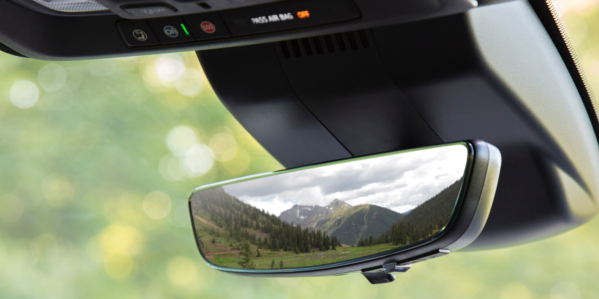 The digital rearview mirror of a 2026 Chevrolet Silverado 1500 shows a mountainscape and rolling hills