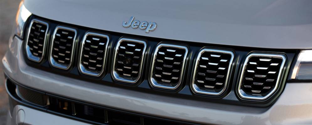 A close up of the 7 slot grille on the front of a silver 2025 Jeep Compass