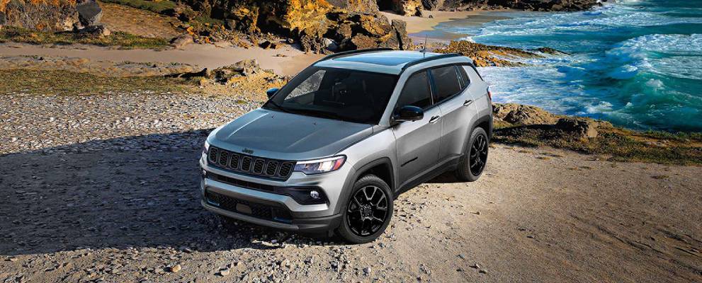 A silver 2026 Jeep Compass is parked on a beach. New 2026 Jeep Compass design features at Leavens Chrysler Dodge Jeep Ram in London, ON