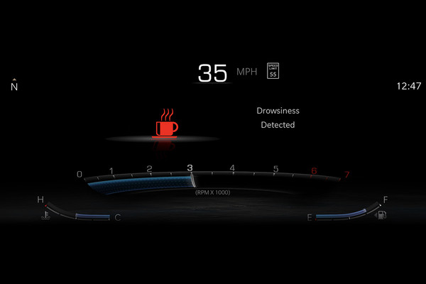 A close-up of the 2025 Jeep Cherokee's dashboard driver display, which shows an alert light in the shape of a red coffee cup.