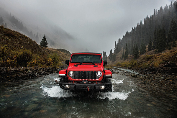A red 2026 Jeep Wrangler crosses water. 2026 Jeep Wrangler performance specs at Leavens Chrysler Dodge Jeep Ram in London, ON