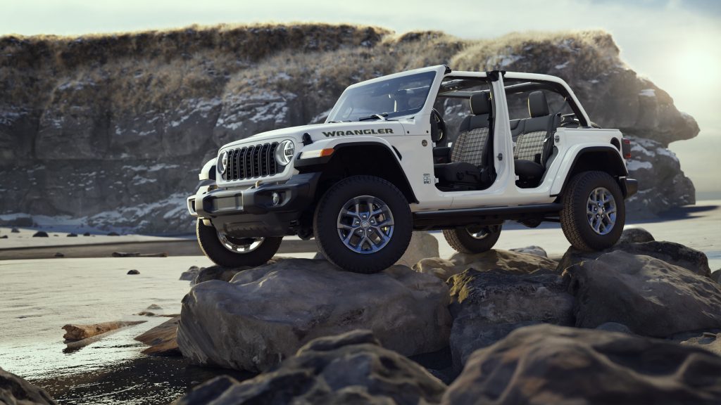 2026 Jeep Wrangler 85th Anniversary Edition in white with doors removed, parked on rocks in a coastal setting, promoted by Leavens Chrysler Dodge Jeep RAM London Ontario.