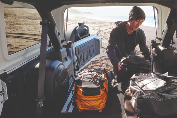 A person loads bags and gear into the 2026 Jeep Wrangler's cargo space. New 2026 Jeep Wrangler Design Features at Leavens Chrysler Dodge Jeep Ram in London, ON