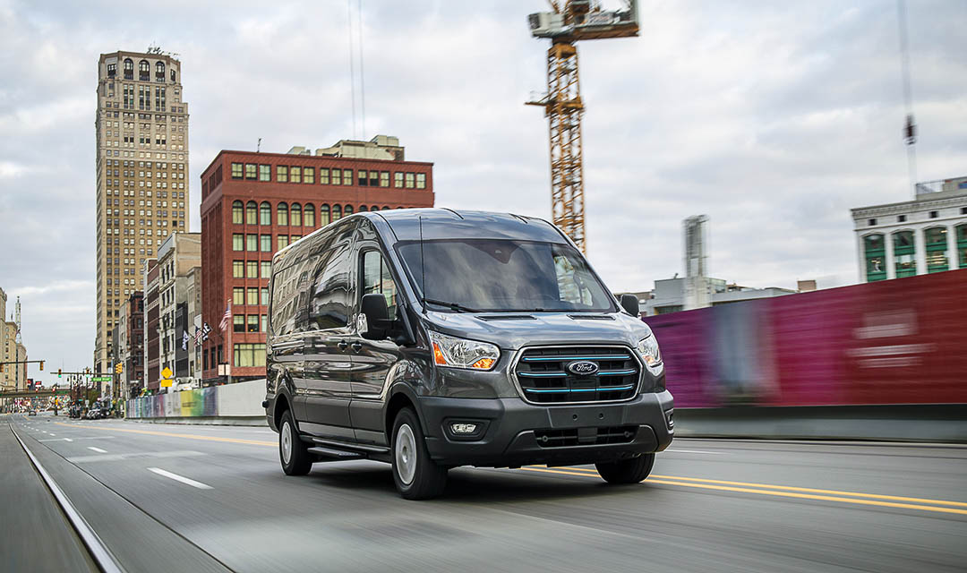 vue trois quart avant du Ford E-Transit 2022 roulant sur une route en ville