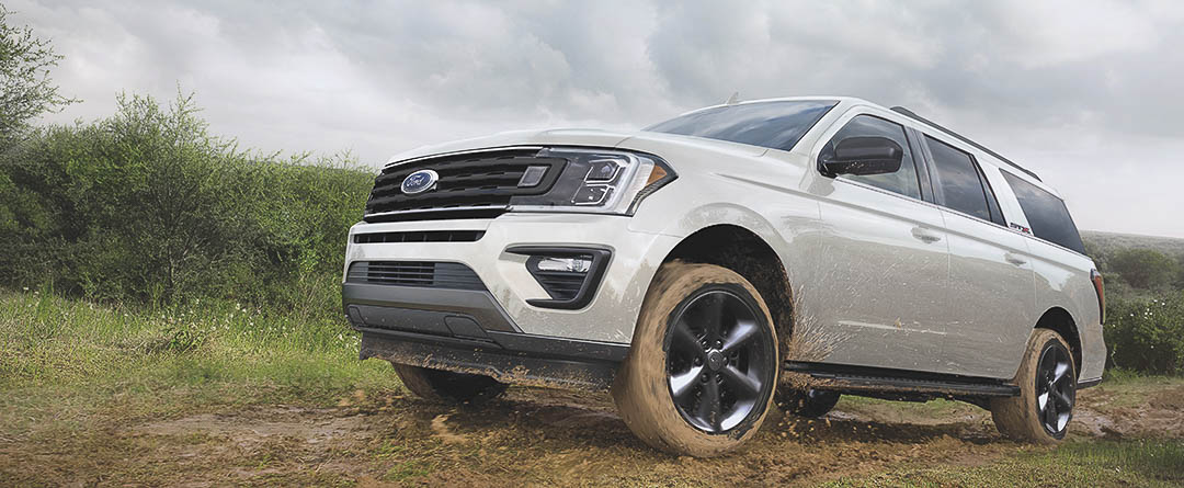 vue latérale du Ford Expedition 2021 roulant sur un sentier hors piste boueux