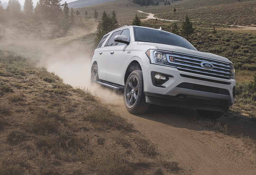 vue trois quart avant du Ford Expedition 2021 roulant sur un sentier de terre