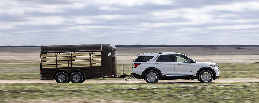 vue latérale du Ford Explorer 2021 roulant sur une route en tirant une remorque