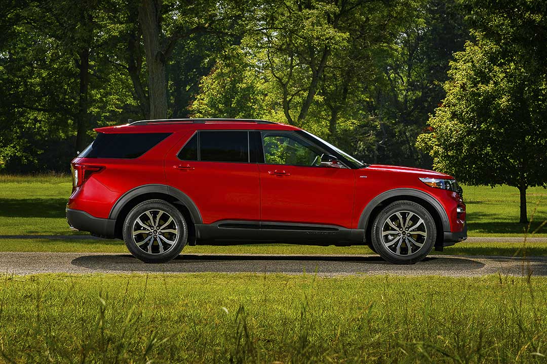 Vue latérale d'un VUS Ford Explorer ST Line 2022 rouge garé dans un parc urbain