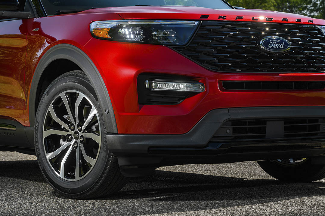 Vue proche de 3/4 avant du Ford Explorer ST Line 2022 rouge incluant sa calandre et ses jantes de 20 pouces