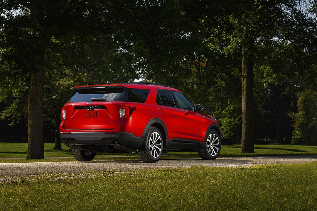 Vue 3/4 arrière du VUS Ford Explorer ST Line 2022 rouge garé dans un parc urbain