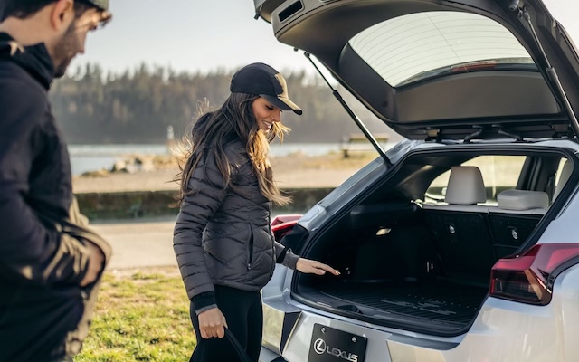 A woman loads the back of a 2025 Lexus UXh.
