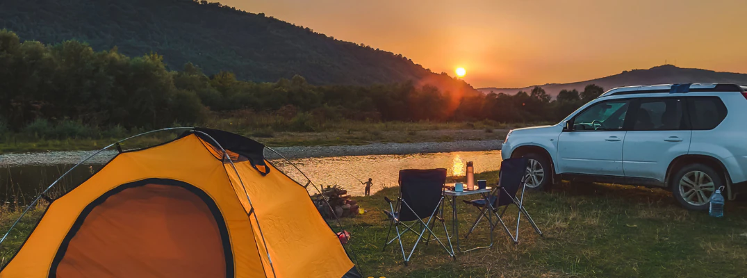 Camping site surrounded by greenery while the sun is setting