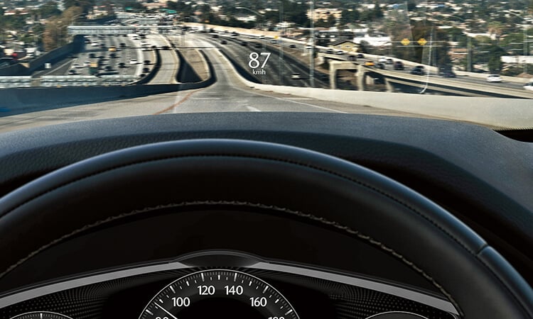 A first-person view through the windshield of the 2025 Mazda CX-90 with its head-up display active