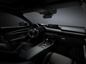 A 2025 Mazda3's front row interior with grey gradient outside the windows