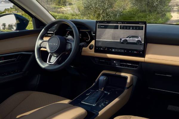 The tan interior of a 2026 Mazda CX-5 showcasing its infotainment touchscreen