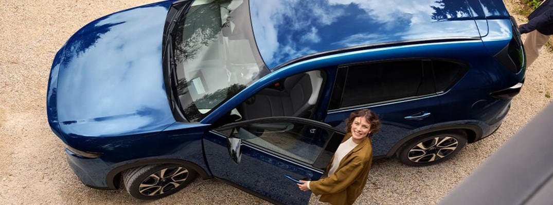 A photo of a person standing in front of a 2026 Mazda CX-5.