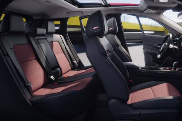 The interior cabin of the 2026 Nissan Kicks with red and black seats