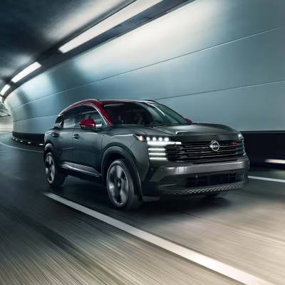 A silver 2026 Nissan Kicks with a red roof drives through a tunnel