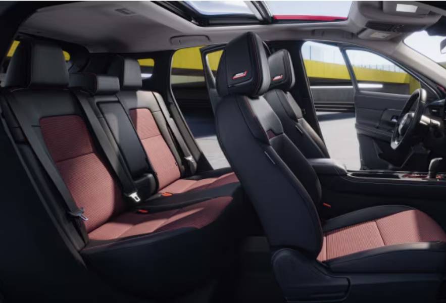 A side view of the 2026 Nissan Kicks' cabin showing black seats with red accents