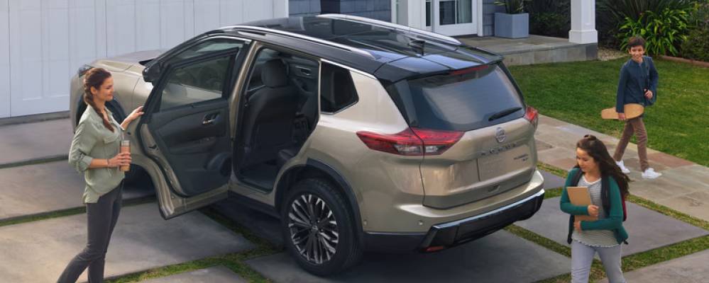 A family boards a gold 2026 Nissan Rogue. Why the Nissan Rogue is the Perfect Road Trip Vehicle at Medicine Hat Nissan in Medicine Hat, AB