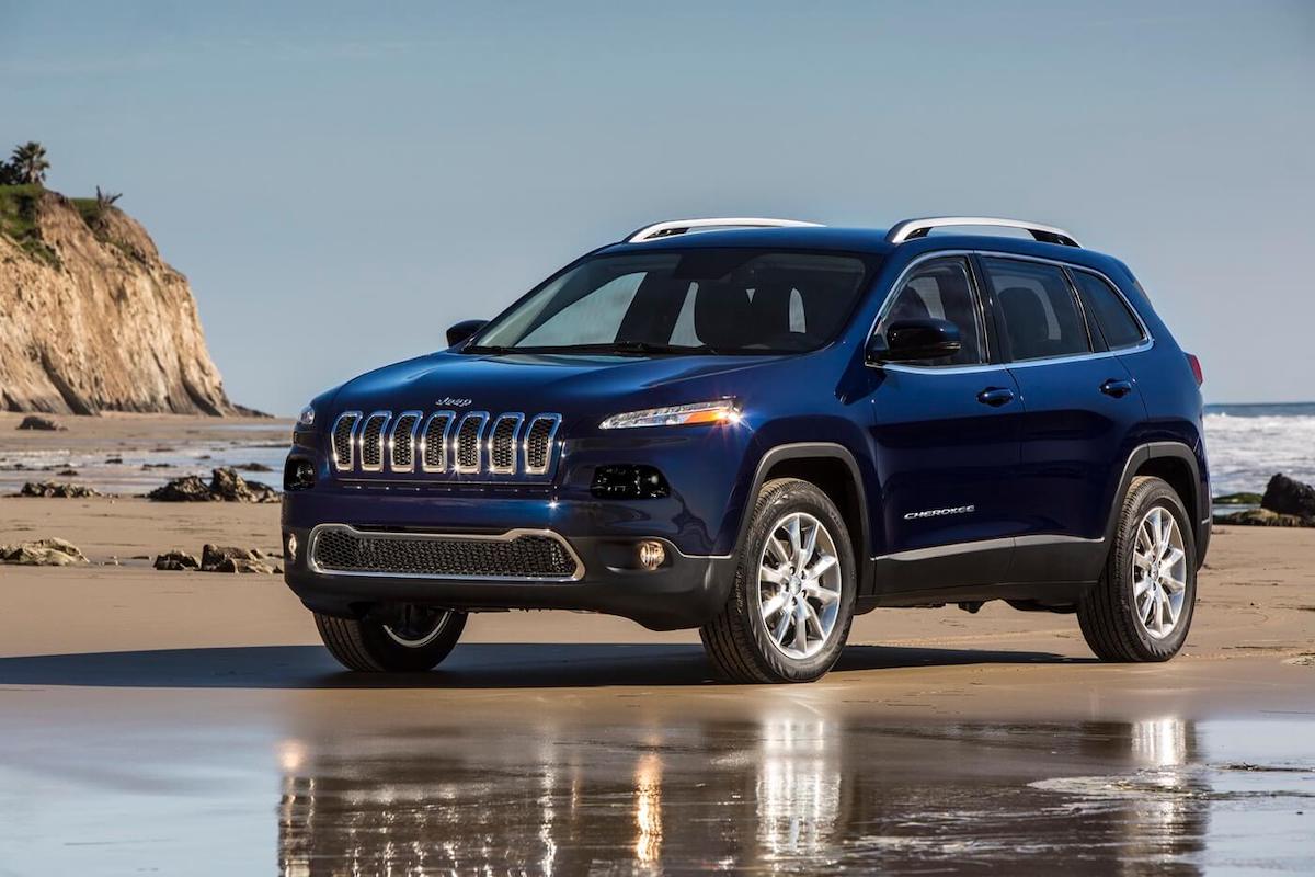 vue 3/4 avant d'un VUS 4x4 Jeep Cherokee Limited 2016 garé sur une plage
