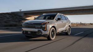 A 2026 Kia Sportage drives under an overpass on the highway. New 2026 Kia Sportage for sale in Miramichi, NB at Miramichi Kia