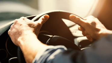 Person gripping onto steering wheel