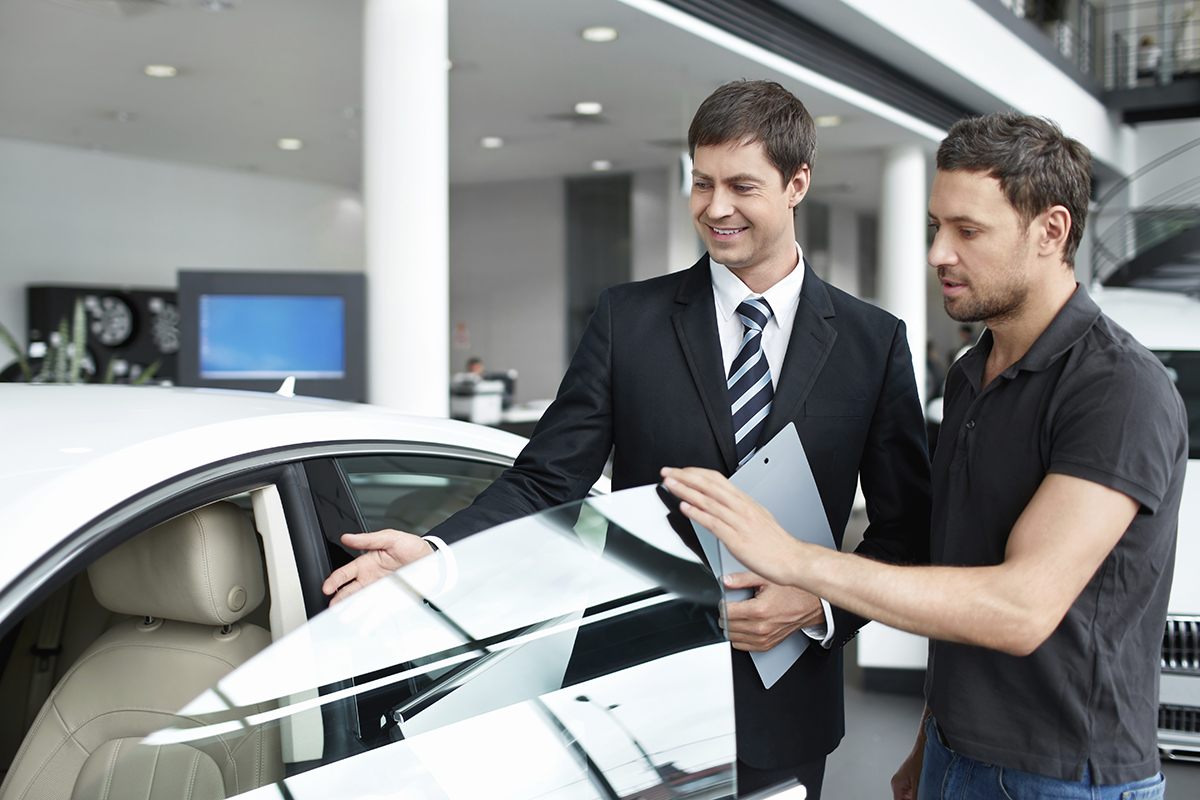 Young man with a salesman in a motor show