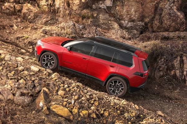 A red 2026 Jeep Cherokee climbs a rocky incline. New 2026 Jeep Cherokee for sale at Orangeville Chrysler Dodge Jeep Ram in Orangeville, ON