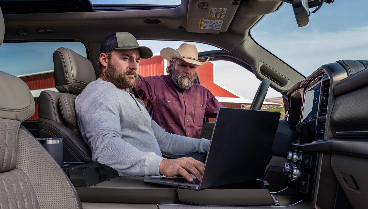 Unknown people looking at laptop screen inside 2026 Ford F-150