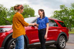 Unknown person handing Ford employee a key.