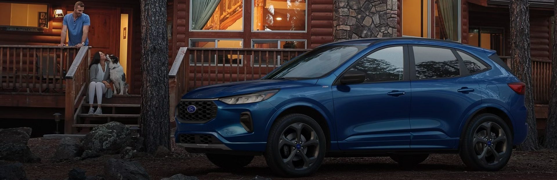People sitting outside house with Ford SUV parked nearby