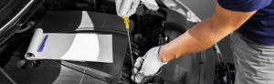 Tech examining oil with dipstick